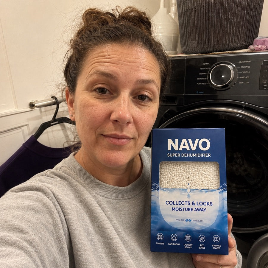NAVO customer holding a boxed dehumidifier in a laundry room