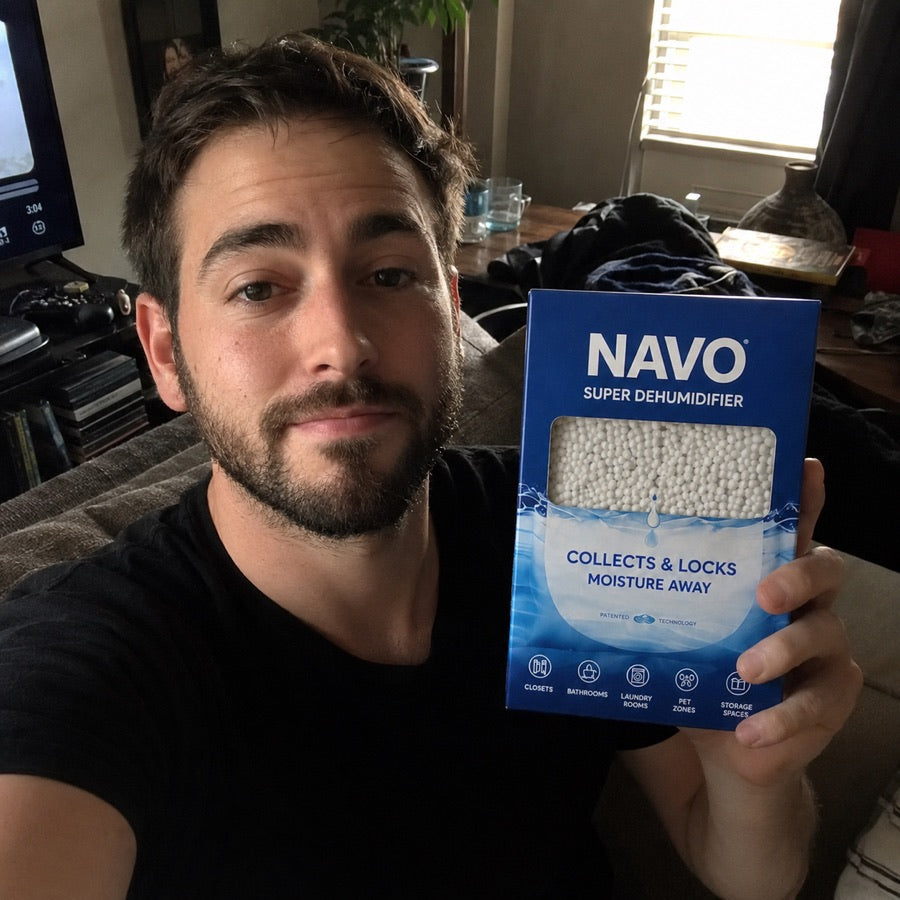 NAVO customer holding a boxed dehumidifier at home