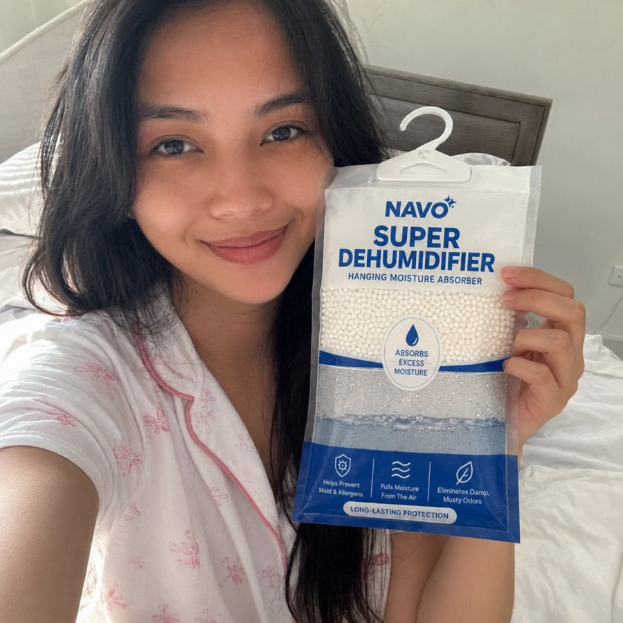 NAVO customer holding a hanging moisture absorber in bed