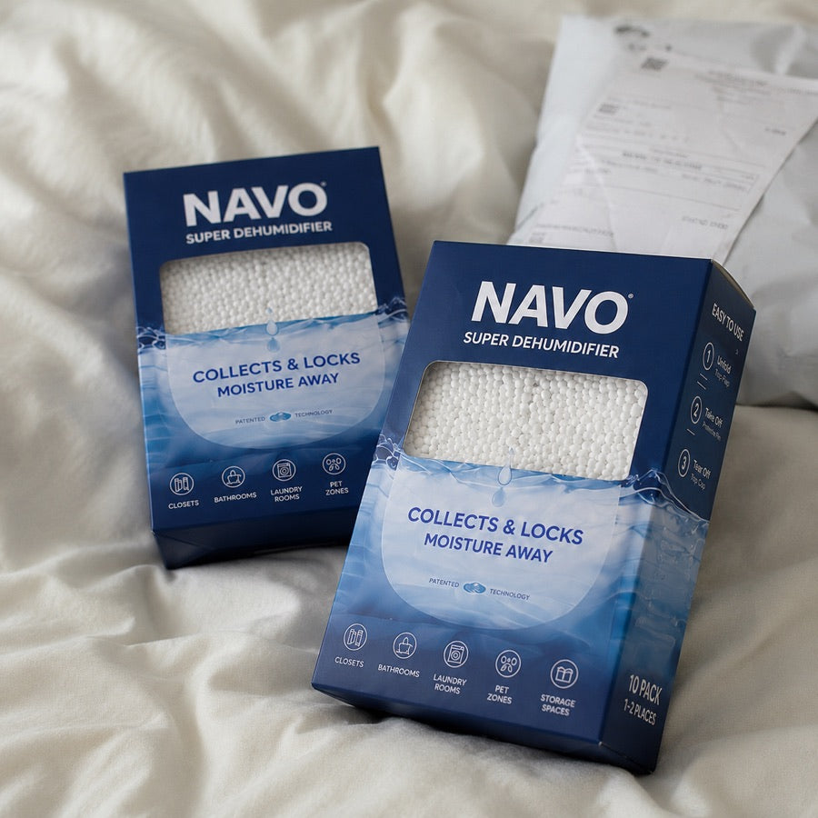 NAVO boxed dehumidifiers on a bed